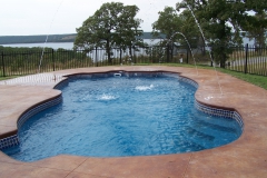 Beautiful fiberglass pool with lake backdrop.